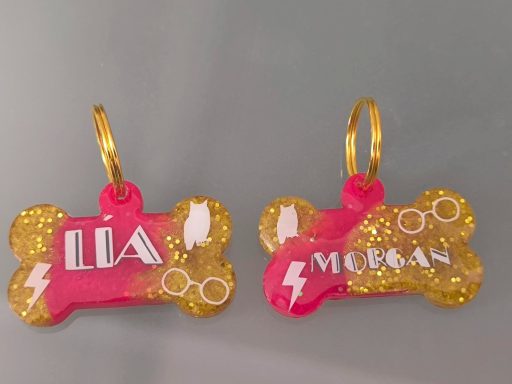 Placas de identificación en forma de hueso con los nombres "Lía" y "Merrian" en colores brillantes.